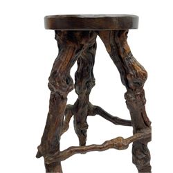 Mid-20th century French grapevine and walnut bow-front wine tasting bar, the curved counter top supported by sculptural grapevine roots, fitted with single shelf and raised on rustic vine feet (W100cm H101cm); with a pair of matching bar stools, the circular top raised on three gnarled root supports united by stretchers (W50cm H70cm)
