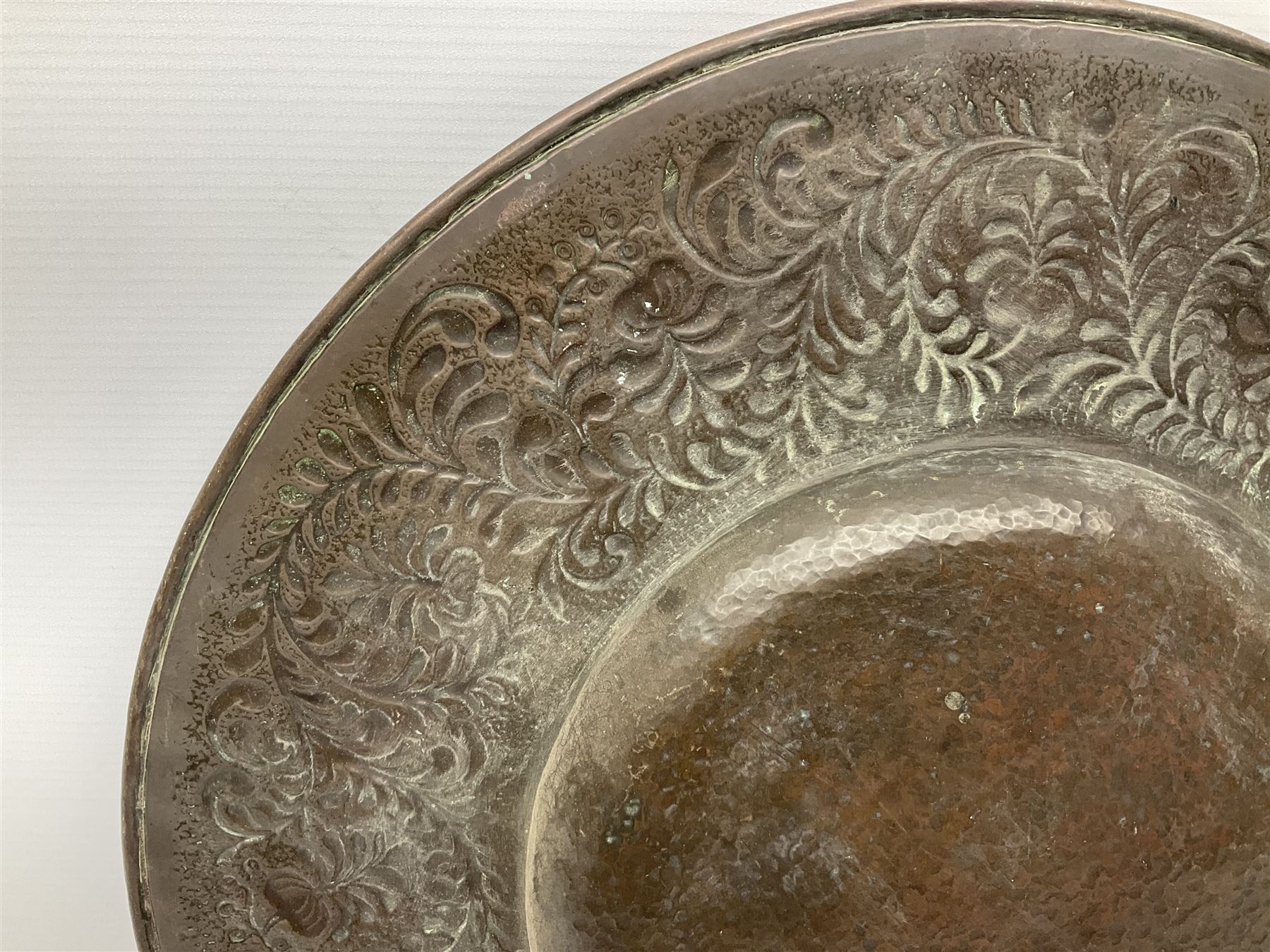 Arts and Crafts Keswick School of Industrial Arts copper charger, decorated with planished centre and repousse scrolling foliate tendrils to rim, D44cm