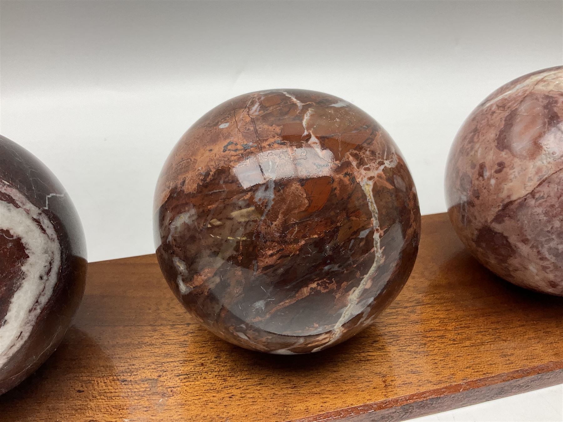 Set of three marble spheres on a elongated octagonal wooden base, H12cm