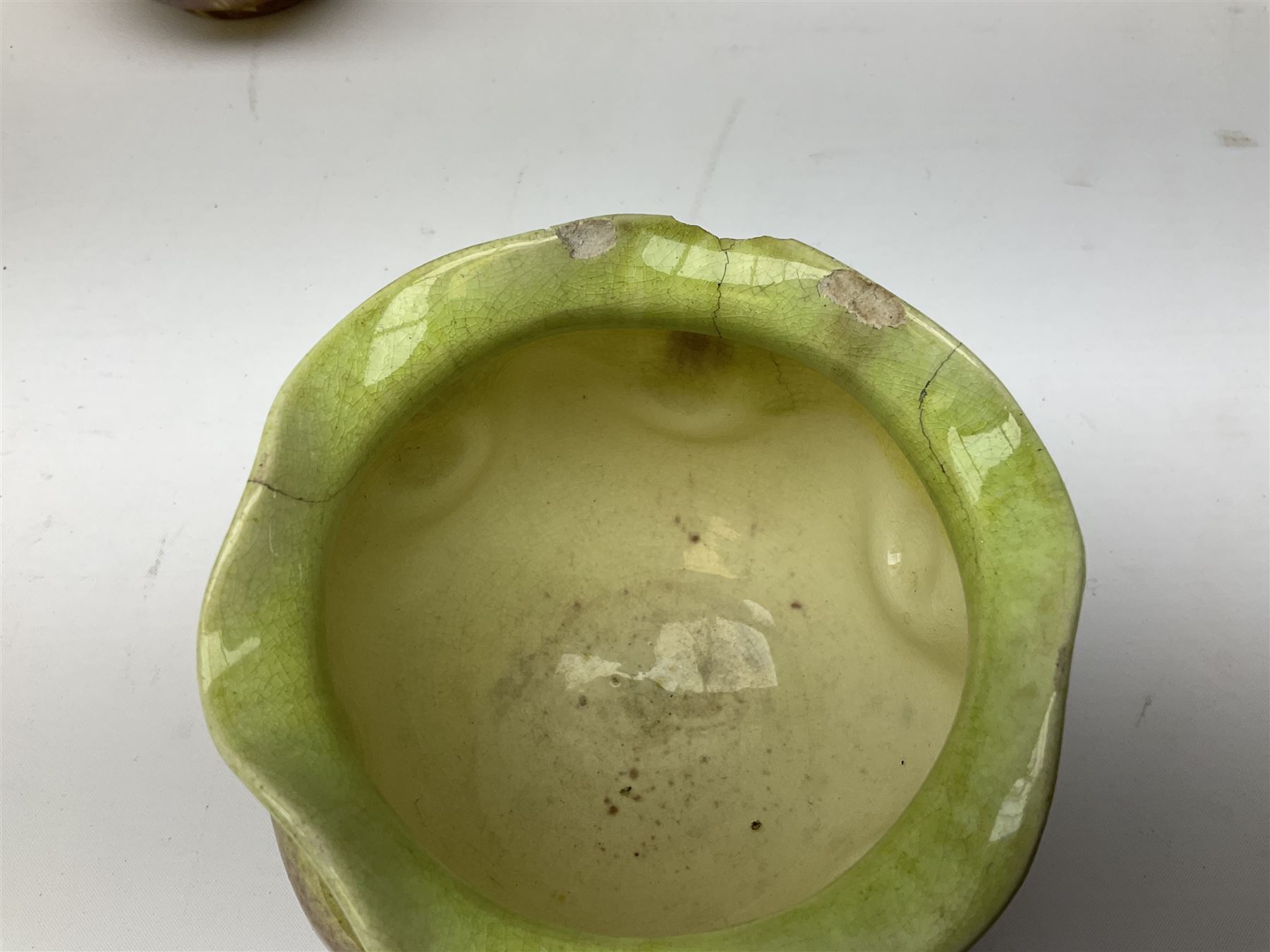 Linthorpe pottery vase with crimped rim and ovoid body, Linthorpe jug with high loop handle and crimped spout, a pair of candlesticks with a green, brown glaze and other similar pottery 
