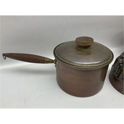 Four Victorian copper moulds, together with a graduating set of copper pans with wooden handles and finials to covers, largest pan 