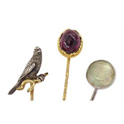 Three Victorian stick pins including silver and gold falcon / kestrel bird, gold cabochon garnet and silver carved 'Man in the Moon' moonstone