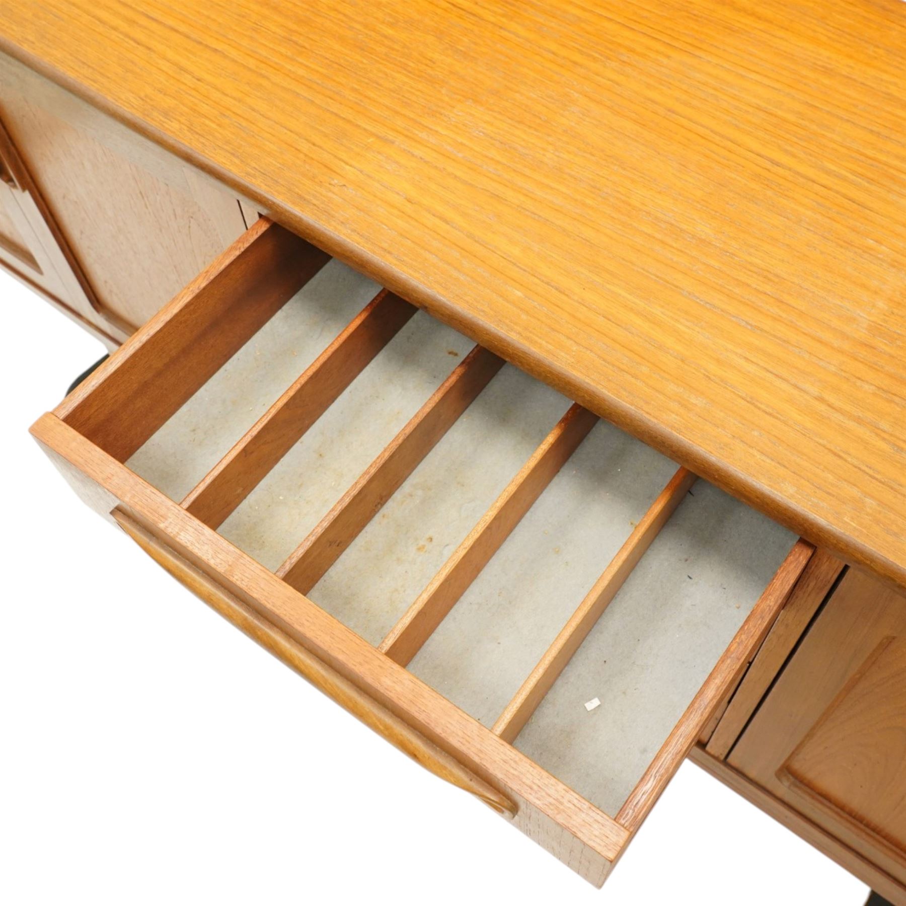 G-Plan - 'Fresco Long John' teak mid 20th century sideboard, a central bank of four drawers, flanked by twin cupboard doors, with recessed handles, on a tapering supports 