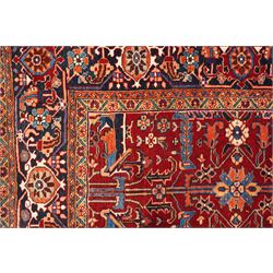 North West Persian Karadja hand-knotted carpet, deep red field decorated with an all-over lattice design of elongated geometric devices interspersed with rosettes and angular palmettes, enclosed by a dark indigo main border of stylized floral and geometric motifs between multiple guard stripes, with cotton fringe ends 