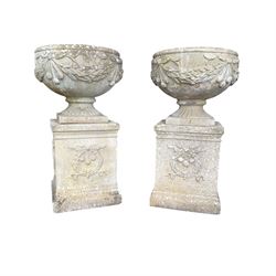 Pair of quality Neoclassical design Haddonstone cast stone garden urns, the globular  body decorated with relief foliate festoons and fruiting motifs, over a fluted socle, the rectangular pedestals with relief foliate wreaths and ribbon garlands