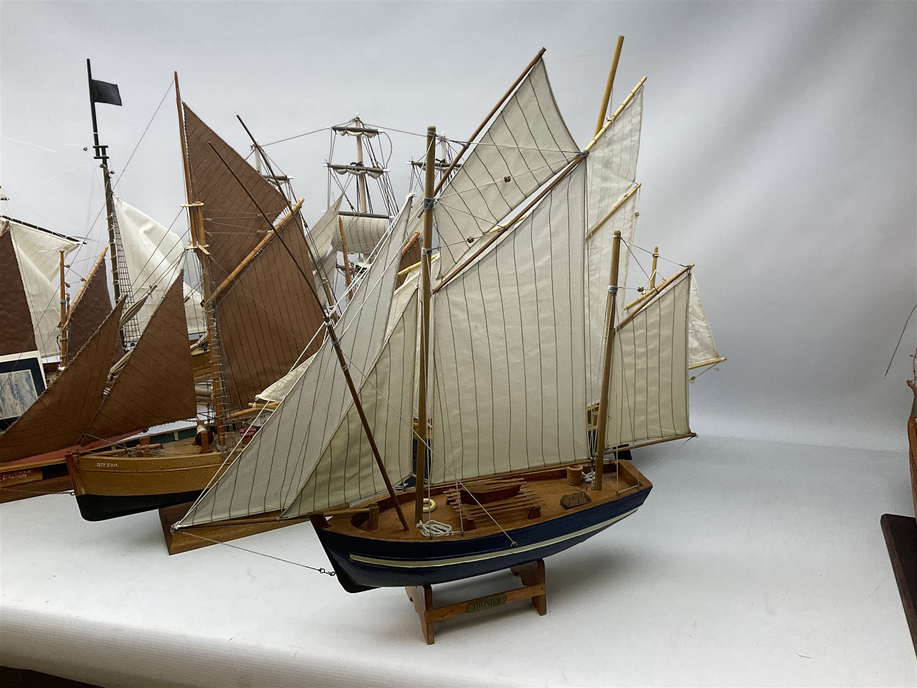 Eight model ships or boats including fishing boat with fish, nets and buoyancy aid, two mast sailing ship complete with cannons, two mast yacht with detailed rigging and life boat etc, the largest L72cm, H60cm