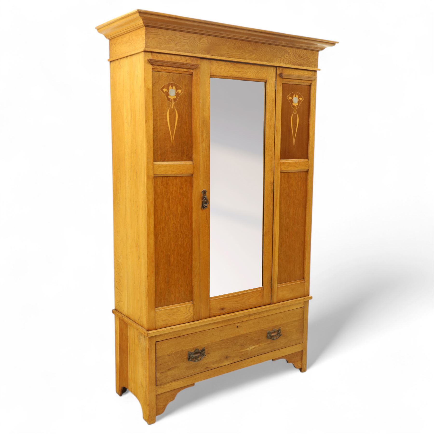 Art Nouveau oak wardrobe, central mirrored door flanked by panels inlaid with stylised tulip motifs, fitted with hanging rail and hooks, single drawer to base with brass handles