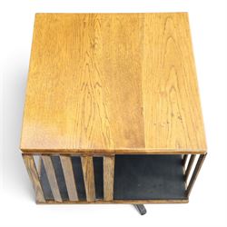 Early 20th century oak revolving bookcase, square top above four divided sections, raised on a revolving base