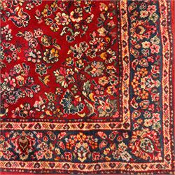 Persian Isfahan-style hand-knotted rug, crimson ground, with an intricated all-over floral spray design with palmettes and leaves, wide midnight blue main border with rosette and palmette motif, flanked by narrow guard borders  