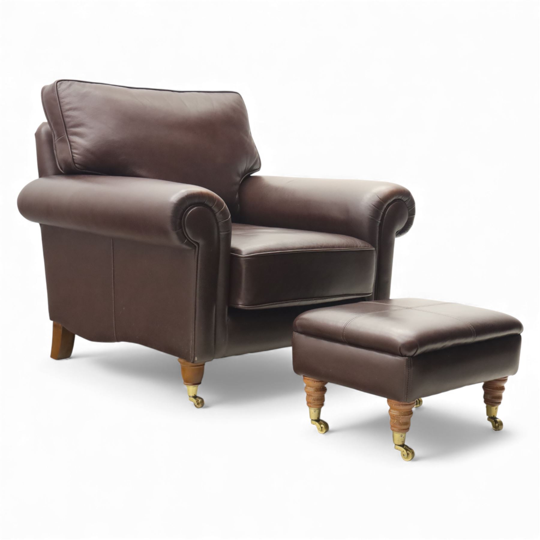 Laura Ashley - brown leather armchair and foot stool, loose cushion back and seat, flanked by scrolled arms upon light stained wood supports on castors, matching brown leather footstool with four panel top over light stained supports on castors (Footstool H 31cm, W 52cm)