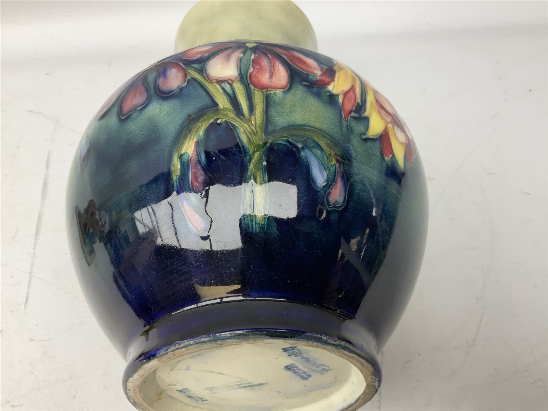 Moorcroft vase of baluster form decorated in the Spring Flowers pattern upon a merging green and blue ground, with impressed and painted marks beneath, H22.5cm