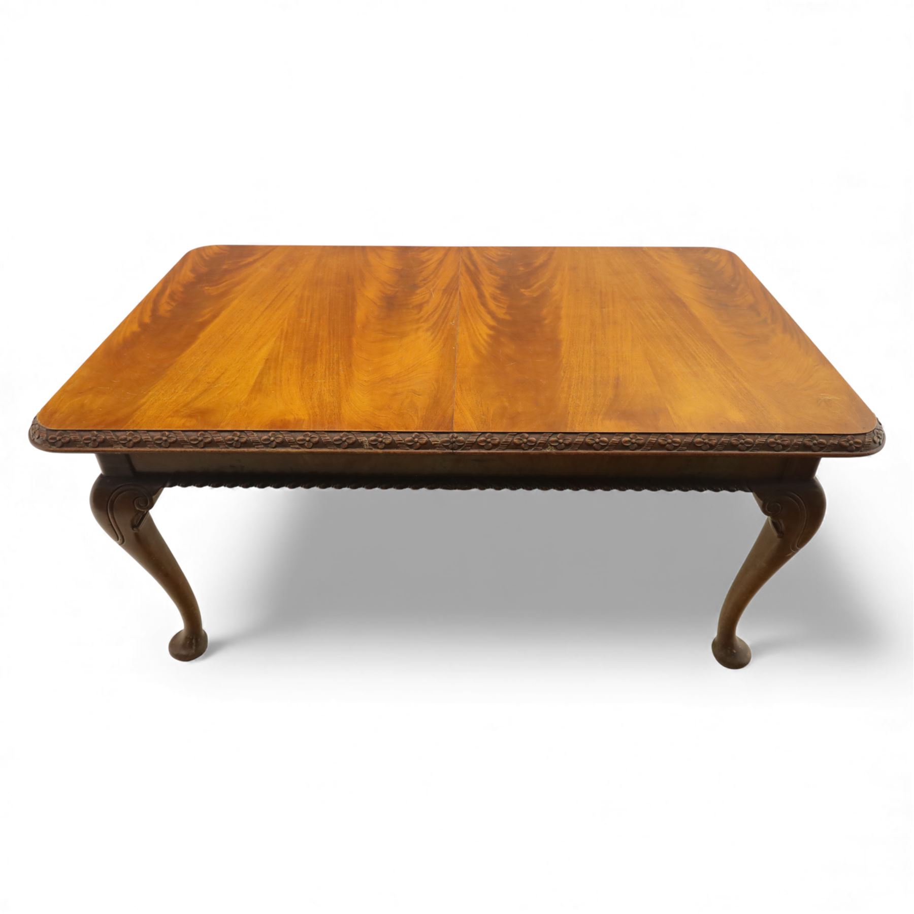 Queen Anne design walnut dining suite, comprising a rectangular dining table with carved moulded edge and rounded corners, raised on cabriole legs terminating in pad feet, together with a set of six matching dining chairs, each with shaped splat back, leather upholstered seat and cabriole supports (Extends to 230cm)