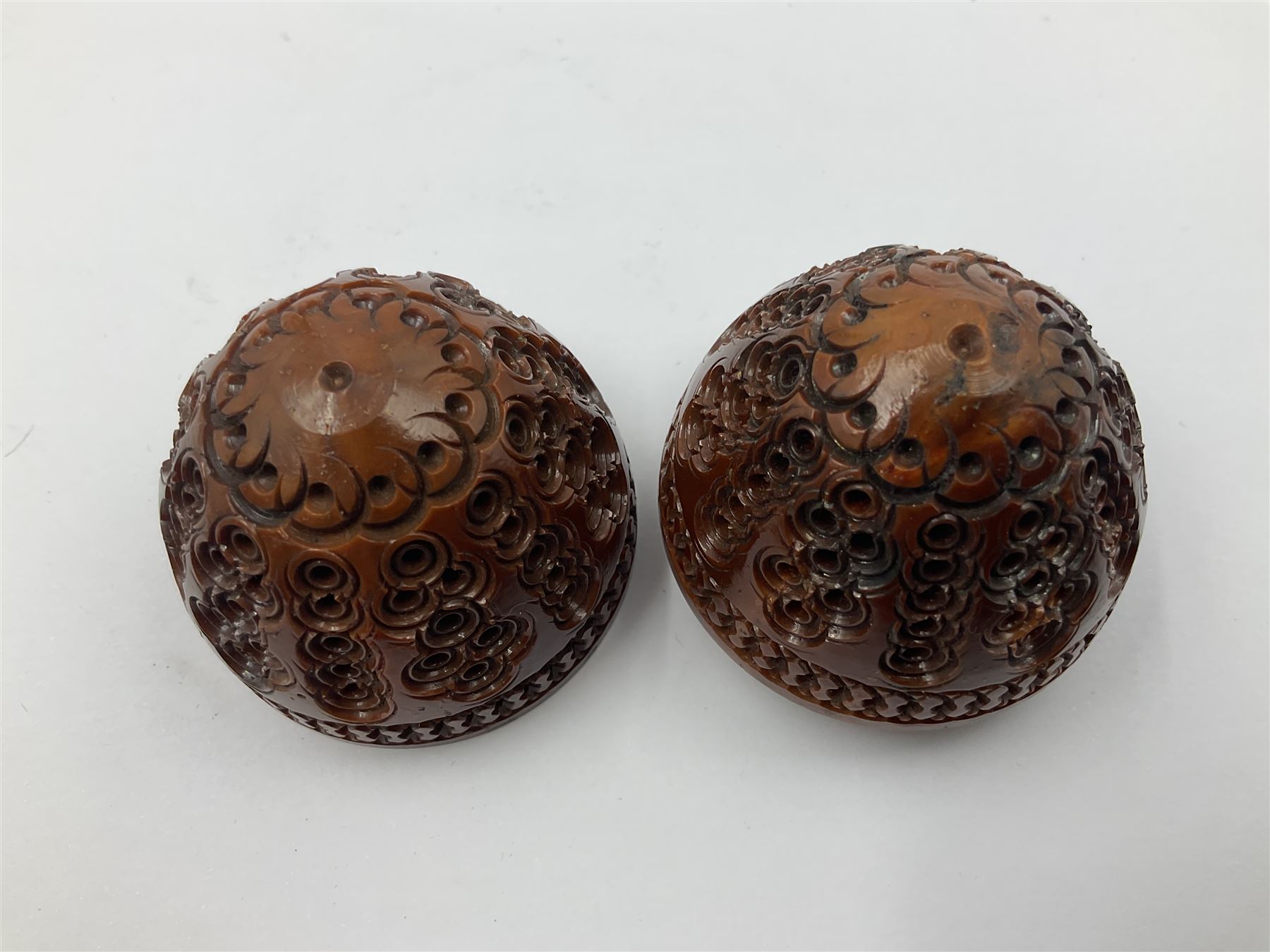 Three 19th century coquilla nut pomanders or flea catchers, two of egg shaped form and the third of barrel from with carved and pierced decoration and screw threaded join, largest H8cm