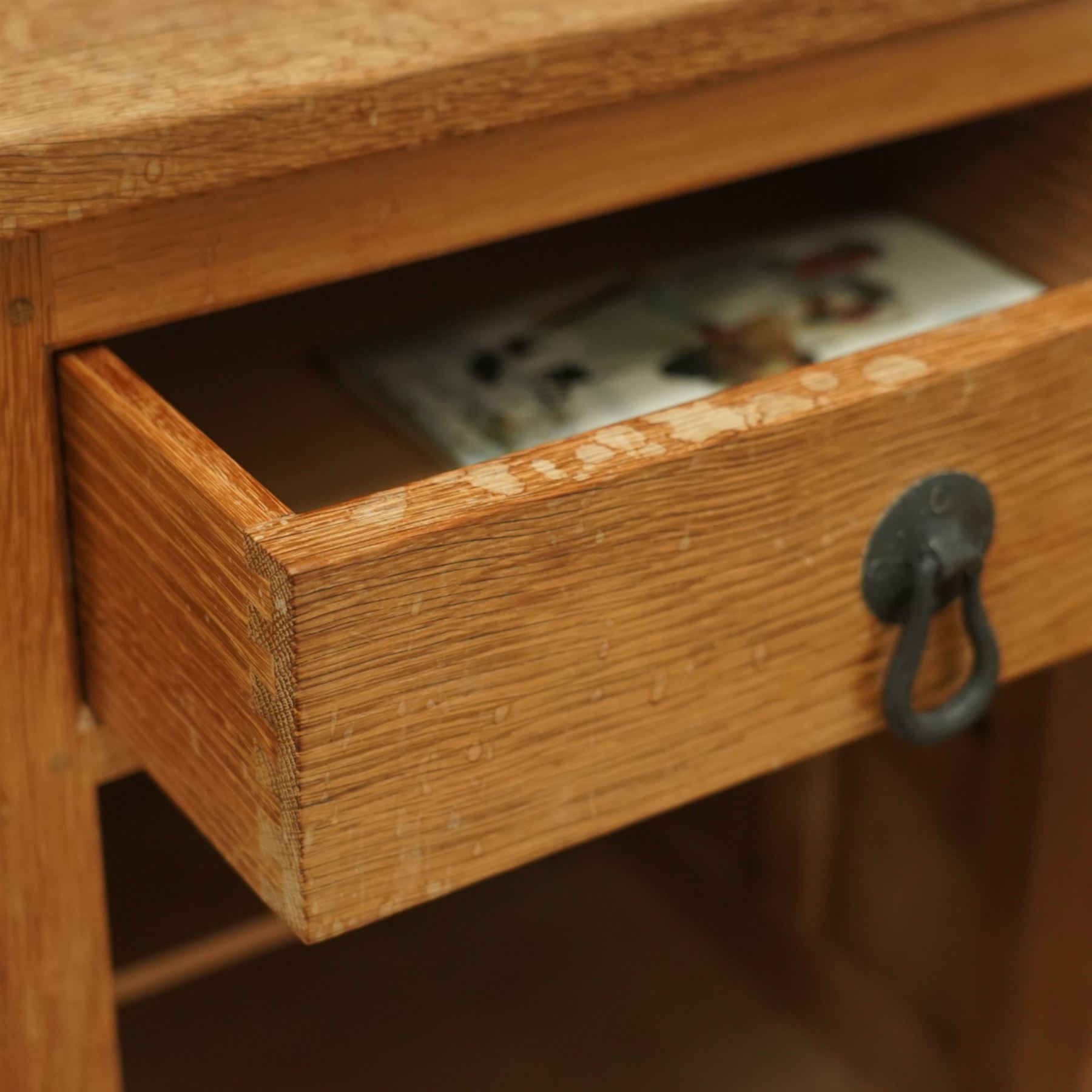 Beaverman - pair of oak bedside cabinets, each with plain rectangular top over single drawer and cupboard below with fielded panels and wrought iron hardware, with signature carved beaver, by the workshop of Colin Almack, Thirsk