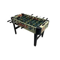 Sportcraft table football game raised on supports with stretcher