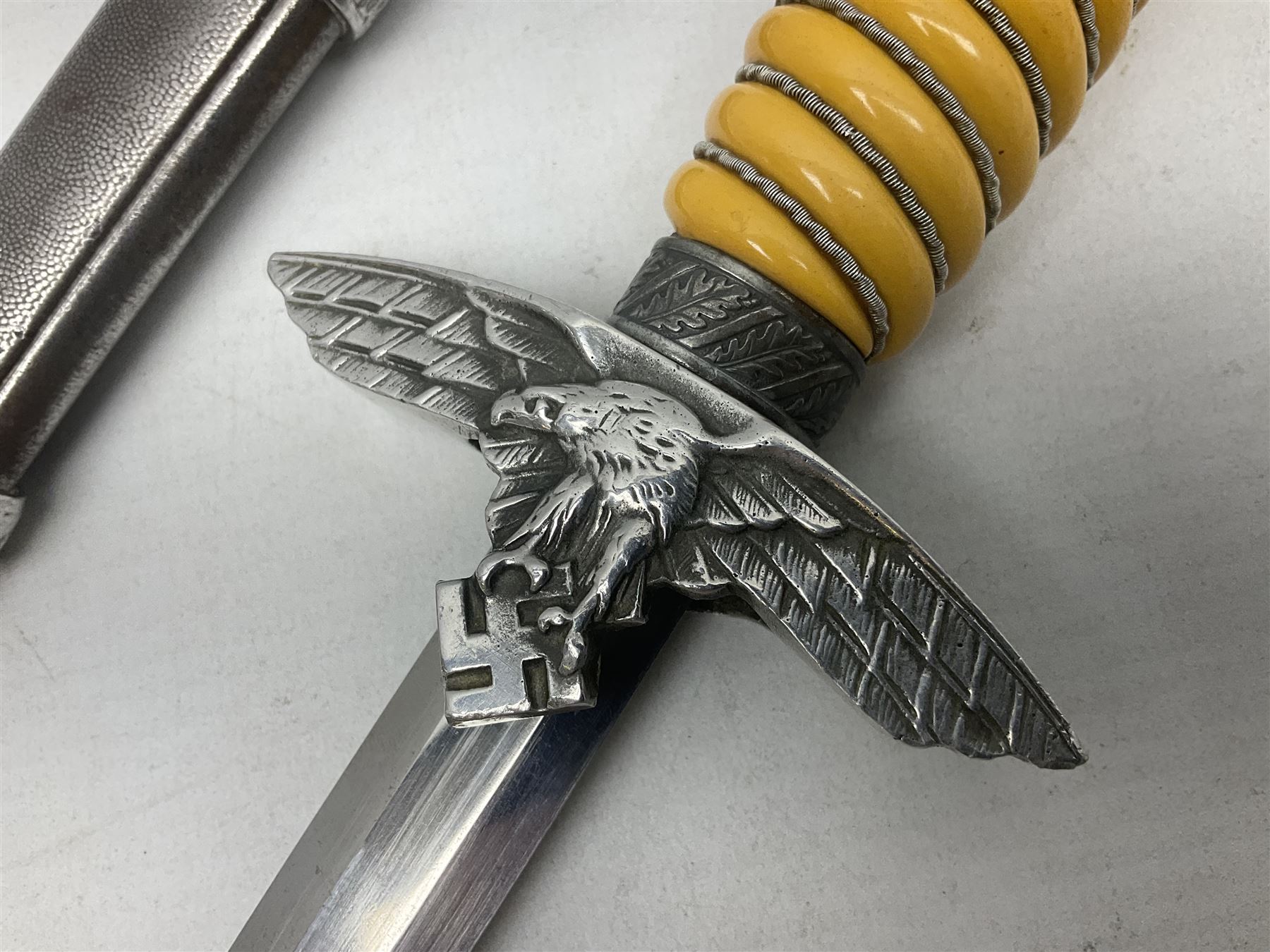 WW2 German Luftwaffe 2nd Pattern Officers dress dagger, with unmarked 25.5cm double edged steel blade, wire-bound pale orange/yellow celluloid grip, globular  pommel with oak leaves and traces of gilding, Luftwaffe eagle cross guard; in beaded scabbard with two suspension rings L43cm overall