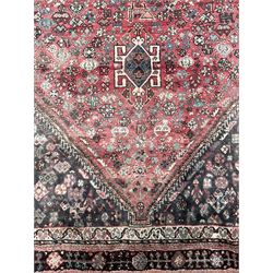 Persian Quashqai  rug, crimson ground extending lozenge on indigo ground field, decorated all over with stylised plant and bird motifs, the main border with repeating floral pattern within multiple geometric design guard bands