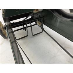Mid 20th century pressed steel pedal car, the body painted in dark green fitted with pretend radiator to the bonnet, with spoked wheels and rubber tyres, the interior with pedals and steering wheel, L70cm