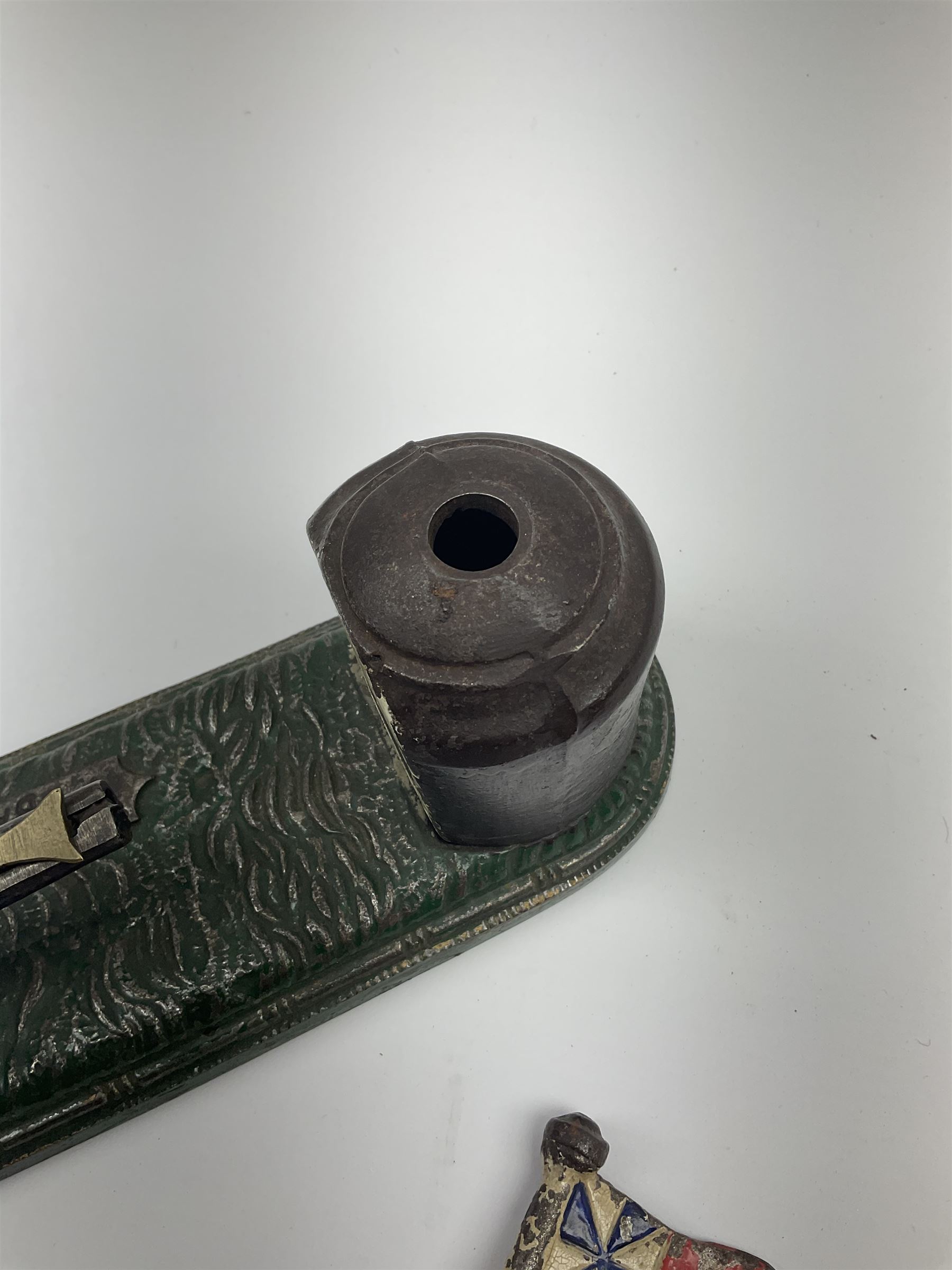 Very rare 19th century John Harper & Co. mechanical cast-iron money box, registered number 33821 patented 1885, inscribed on metal plaque 'Wimbledon Bank', based on the Queen's Trophy for shooting at Wimbledon, depicting a British Infantry man in red tunic and blue trousers lying on the ground using a gun to fire a brass coin launcher into a pill box with removable moving flag above L30cm