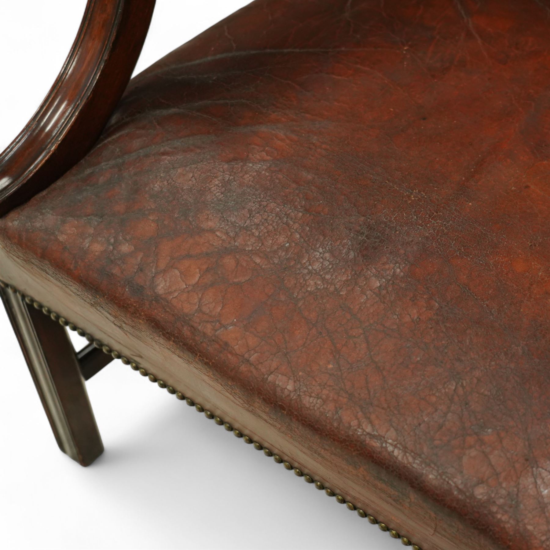 Early 20th-century Gainsborough-style library armchair, padded back, arms, and seat, brass button upholstered in brown leather, on square tapered front legs united by a stretcher 