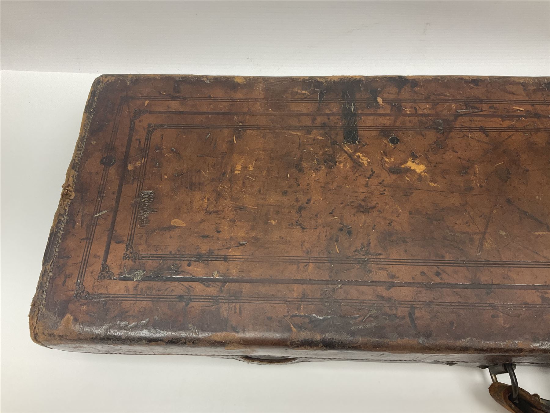 Leather shotgun case, the red baize lined interior with the trade labels of Westley Richards & Co., London, a brass plaque inscribed 'T Nevin, Mirfield, Yorkshire' to cover, with key, case to fit barrel 76cm (30 inches)  
