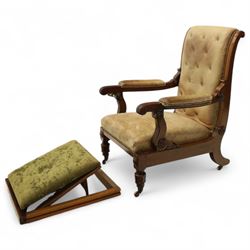 William IV mahogany gentleman's library reclining armchair, leather button upholstered and brass-studded back and seat, above leather-covered arms terminating with carved roundels and foliate scroll-carved ends, underside with brass mechanical trigger reclining lever, the apron with retractable foot rest, supported on lappet carved and turned legs with brass castors, circa 1835