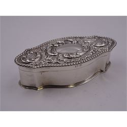 Edwardian silver dressing table box, of shaped oval form, the hinged cover embossed with vacant central panel, scrolling foliate surround, and oblique gadrooned rim, hallmarked William Hutton & Sons Ltd, Birmingham 1901, W13cm, approximate weight 3.83 ozt (119 grams)