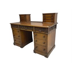 Late 19th century heavily carved oak twin pedestal desk, rectangular top with two raised trinket or correspondence structures each with three drawers, rectangular top over three frieze drawers carved with acorn and oak leaf decoration, each pedestal with three drawers with acorn husk shaped handles