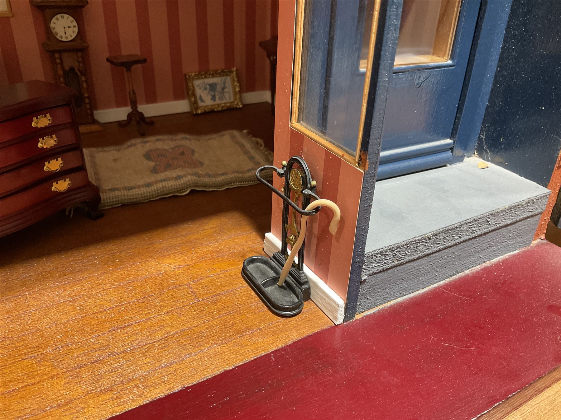 Good quality late 20th century dolls house by M. James dated 1995 in the form of a Beverley East Yorkshire Antique Shop called 'North Bar Antiques'; single-storey single-roomed shop with textured brick walls and flat roof, fully glazed hinged front with recessed hinged customer door and central window to the rear; comprehensively furnished with chests of drawers, pedestal desk, breakfast table, lowboy, two longcase clocks, delft rack with ceramics, occasional tables, pictures, Regency style mirror and collectibles; decorated walls with coving and picture rail and simulated floorboarding; wired for electric lighting; maker's plaque W61cm H42.5cm D41.5cm