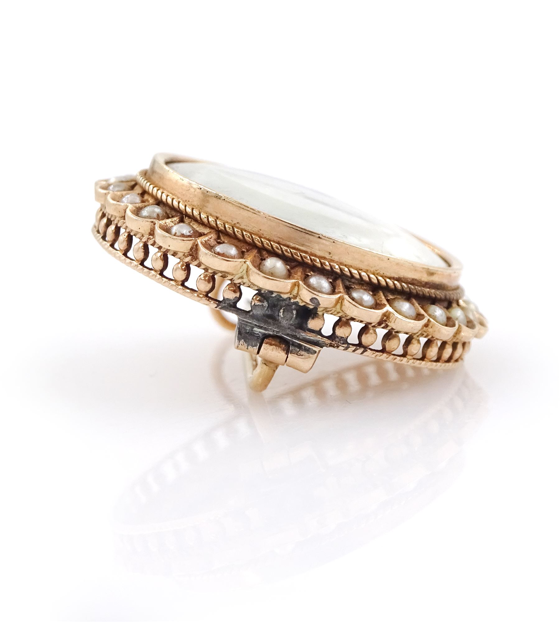 19th century gold pearl portrait brooch, set with a circular miniature of a woman in 18th century dress on ivory, under a glazed panel, with split pearl surround, to a pierced scalloped gallery. This lot has been registered for sale under Section 10 of the APHA Ivory Act