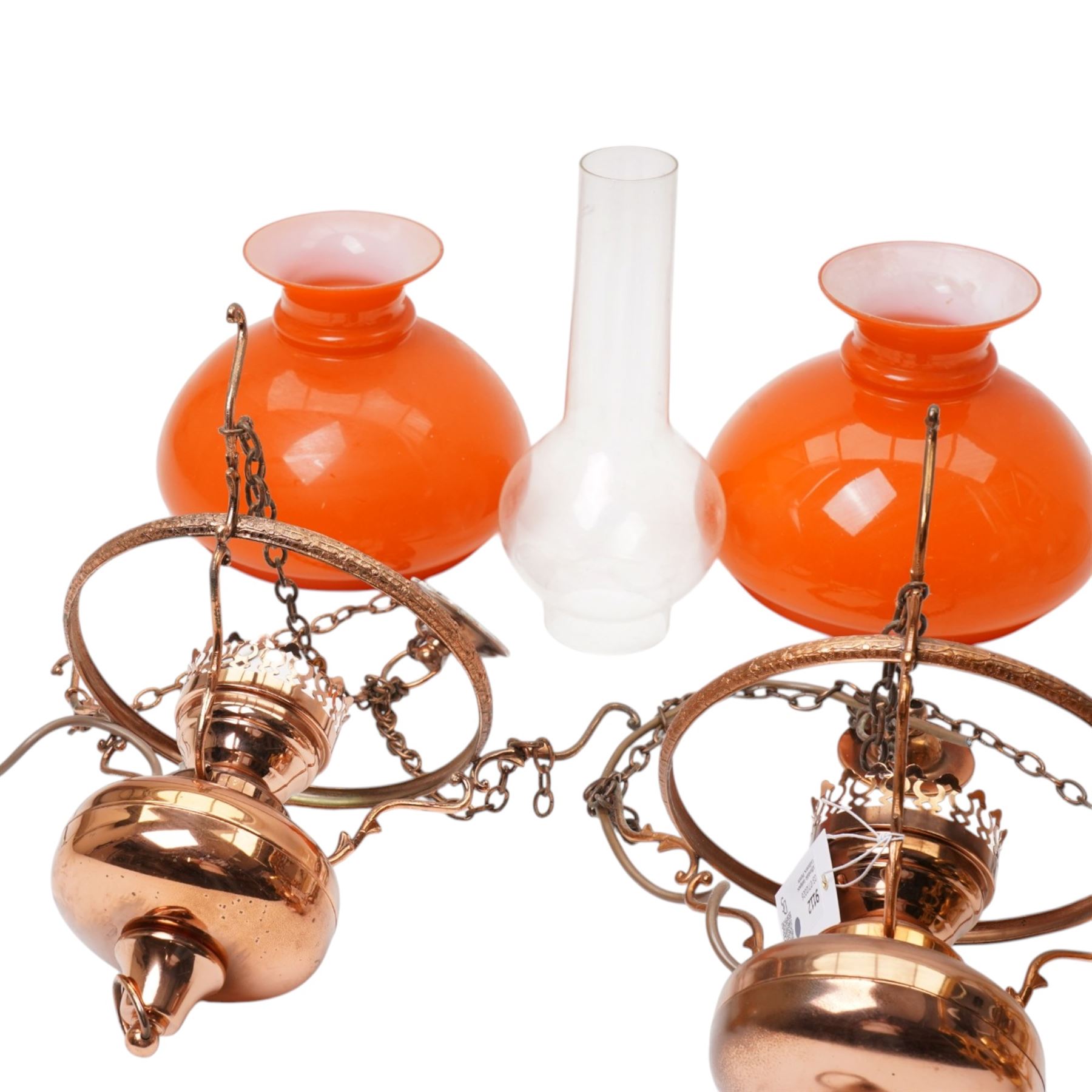 Pair of brass pendant light fittings with orange glass shades and another with partly frosted glass shade 