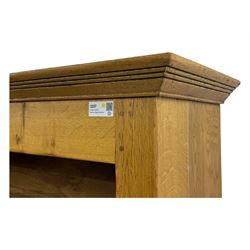 Contemporary French provincial design oak open bookcase, with projecting moulded cornice above a boarded back, fitted with four adjustable shelves, on bracketed plinth base