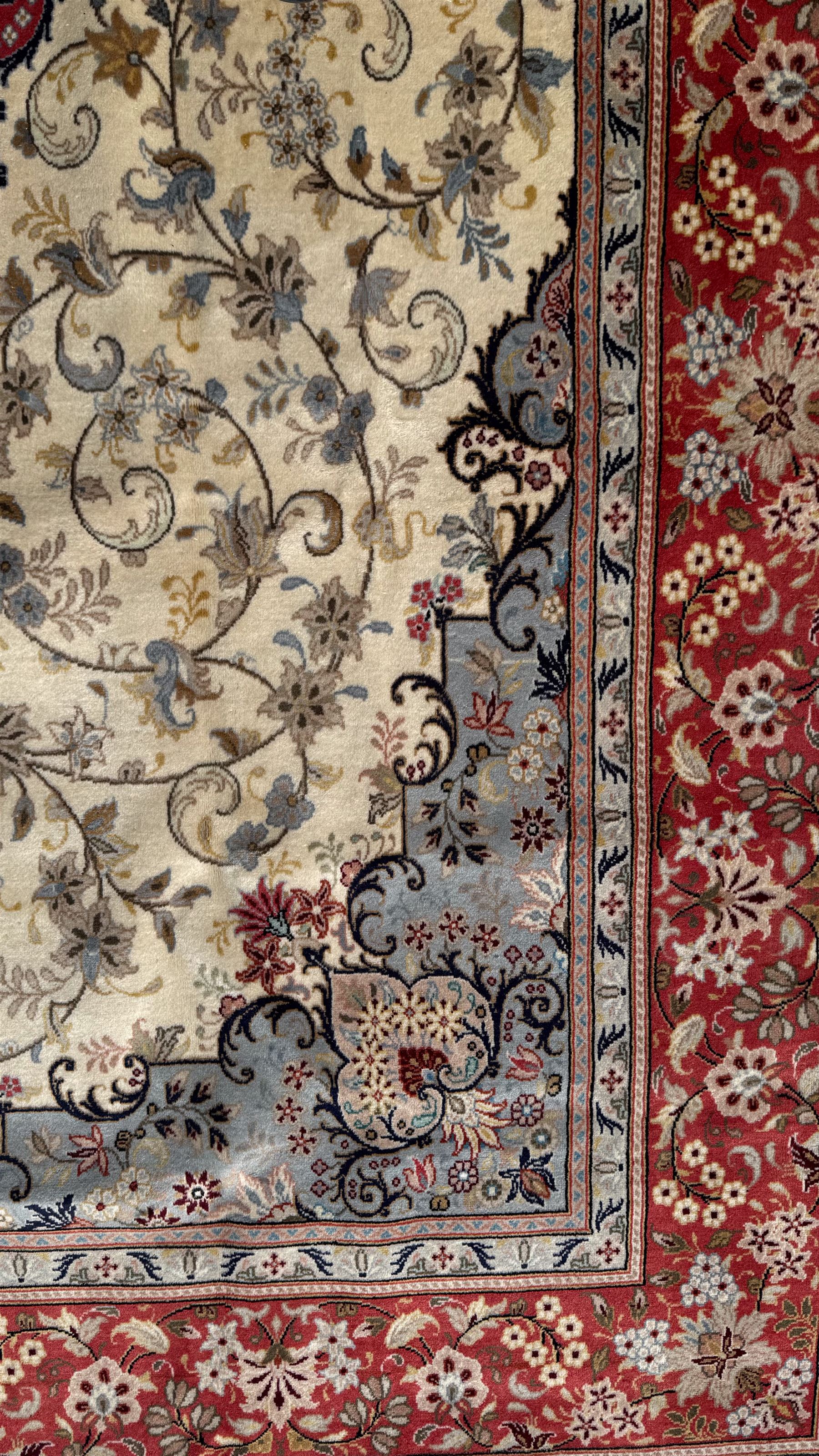 Central Persian Kashan rug, ivory and teal ground, overall geometric design, angular interlaced decorated field with stylised plant motifs, crimson ground, central medallion, the crimson main border band decorated with geometric motifs