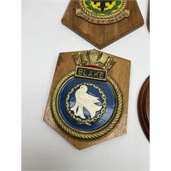 Navy crests upon wooden shields and a brass model anchor 
