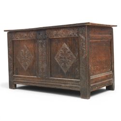 18th century oak coffer with carved frieze and rails, rectangular plank top with iron strap hinges, raised on stile supports