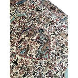 Persian ivory ground 'Tree of Life' design rug, central shaped panel depicting a building with river and trees, the surrounded busy field decorated with trailing branches, trees, animals and birds, the main border decorated with matching motifs, enclosed within guard stripes 