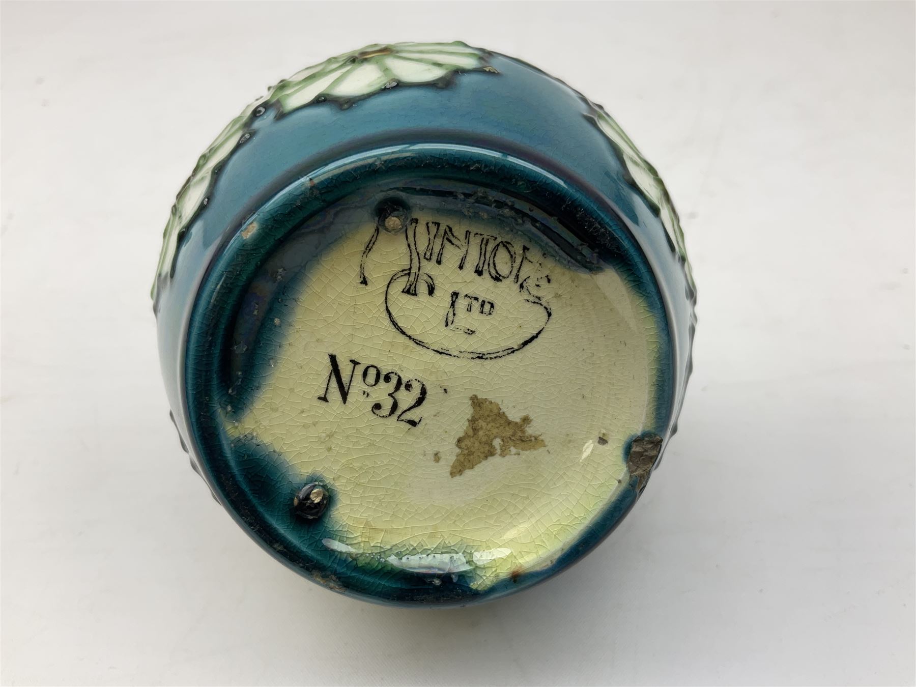 Minton Secessionist vase, with tube-lined stylised flower decoration, upon a blue ground, with printed mark to base 'Minton Ltd, No. 32', H13cm