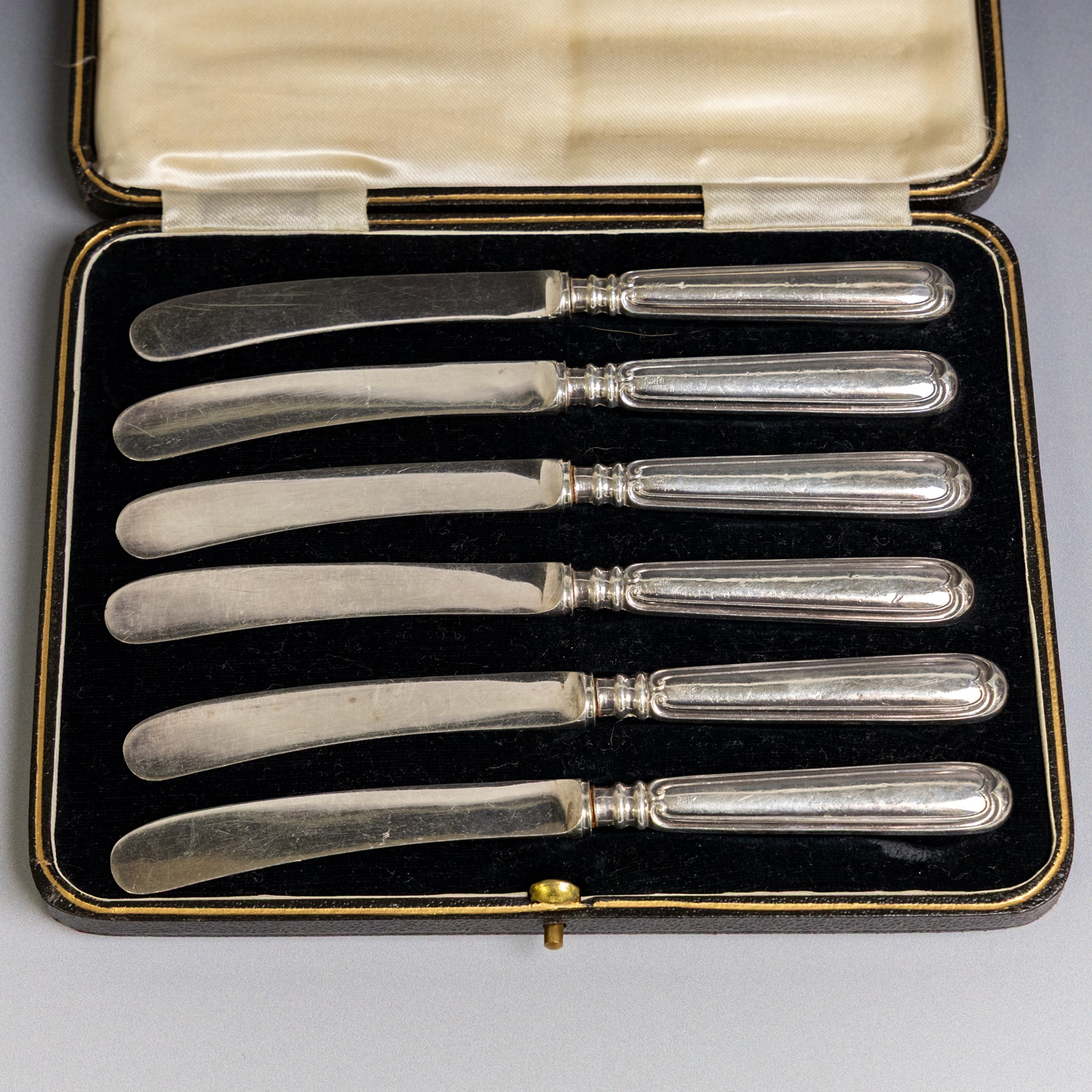 Set of six 1920s silver teaspoons with engraved initials, together with two sets of silver handled tea and fruit knives, all hallmarked and all within fitted cases