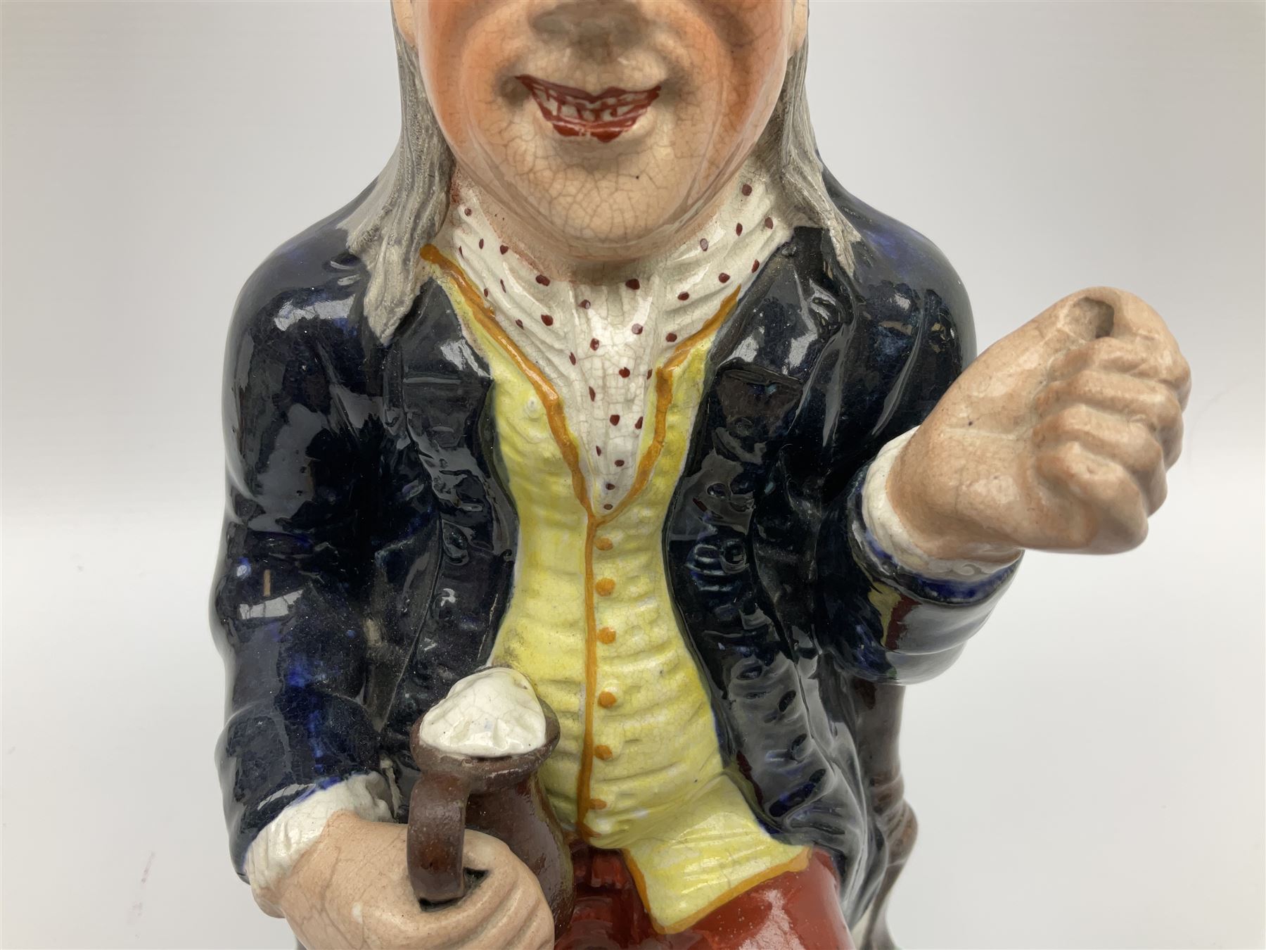 Early 20th century Staffordshire William Kent Squire toby jug, modelled seated upon a corner chair holding a jug of ale in his right hand, H28cm