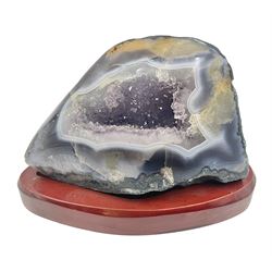 Amethyst crystal geode cluster, with well-defined crystals of various sizes, upon a carved wooden stand, H12cm, L20cm