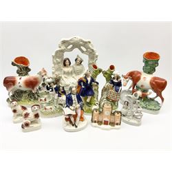 Collection of  Victorian Staffordshire and Staffordshire style pottery, including a man seated writing a letter H18cm, pair of lovers under an arbour H35.5cm, spill vase depicting a cow and calf on a naturalistic base, a pair of spaniels on a cushioned base etc. 