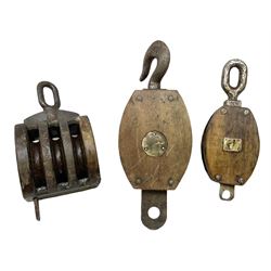 Three ship pulleys comprising wooden block double with stiff swivel hook, wooden block triple with swivel eye and wooden block with swivel eye, largest example L49cm