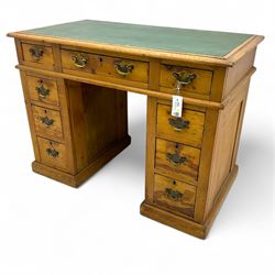 Rustic pine twin pedestal desk, rectangular green leather inset top above a central frieze drawer flanked by two short drawers, each pedestal featuring three graduated drawers, raised on a plinth base