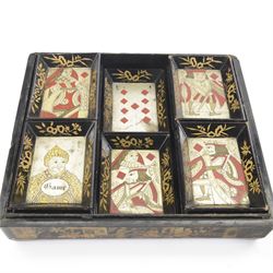 19th century Chinese export black lacquered games box, of rectangular form decorated to the exterior with figures, pagodas and bridges in a riverside landscape in red and gilt, the lift off cover opening to reveal a compartmented interior with four removable covered boxes decorated with conforming figural scenes, and eight trays decorated with stylised suits, H10cm W30cm D27cm