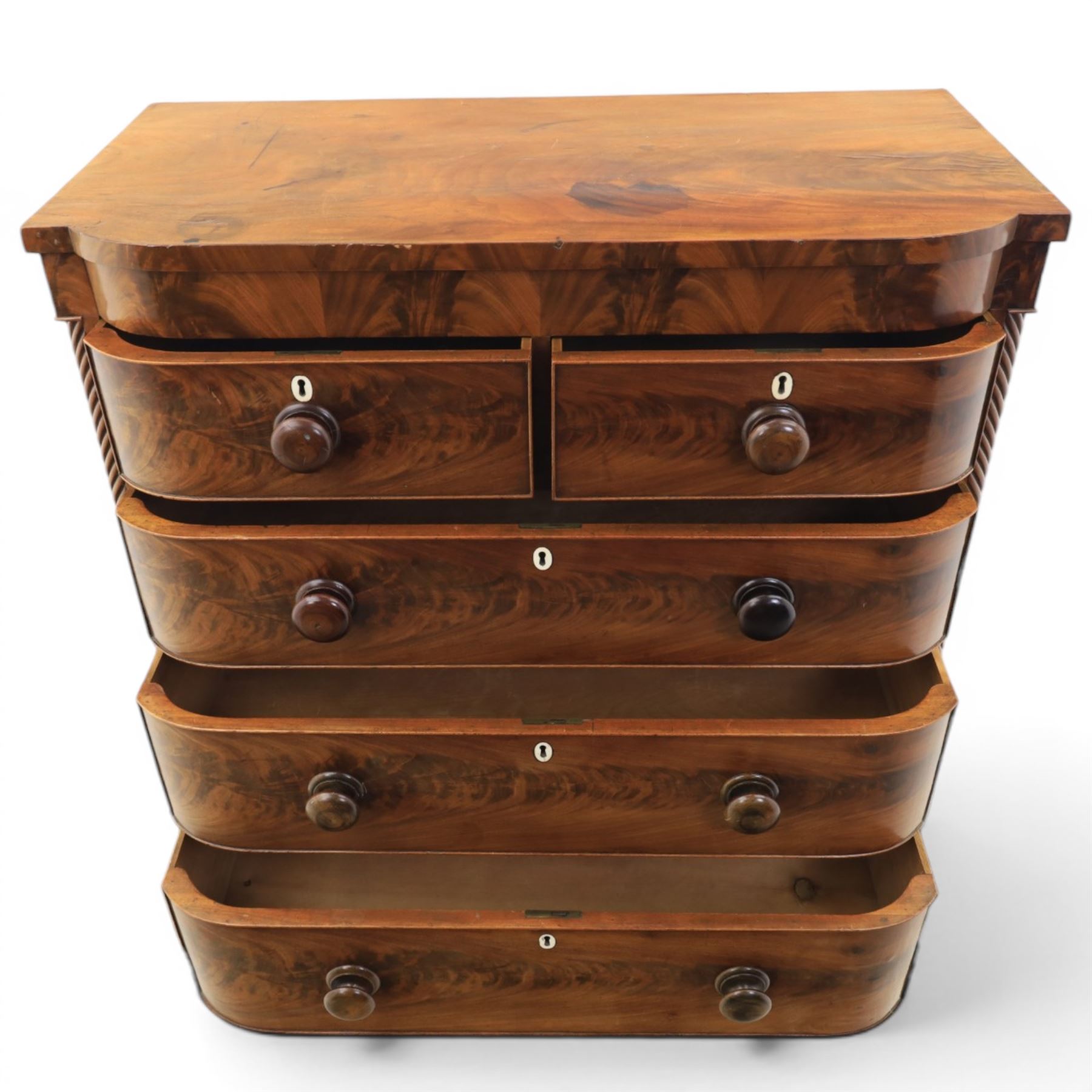 Victorian mahogany bow fronted chest, fitted with two short and three long drawers, flame mahogany front, bone escutcheons and turned wooden handles, quarter barley twist columns, raised on turned supports