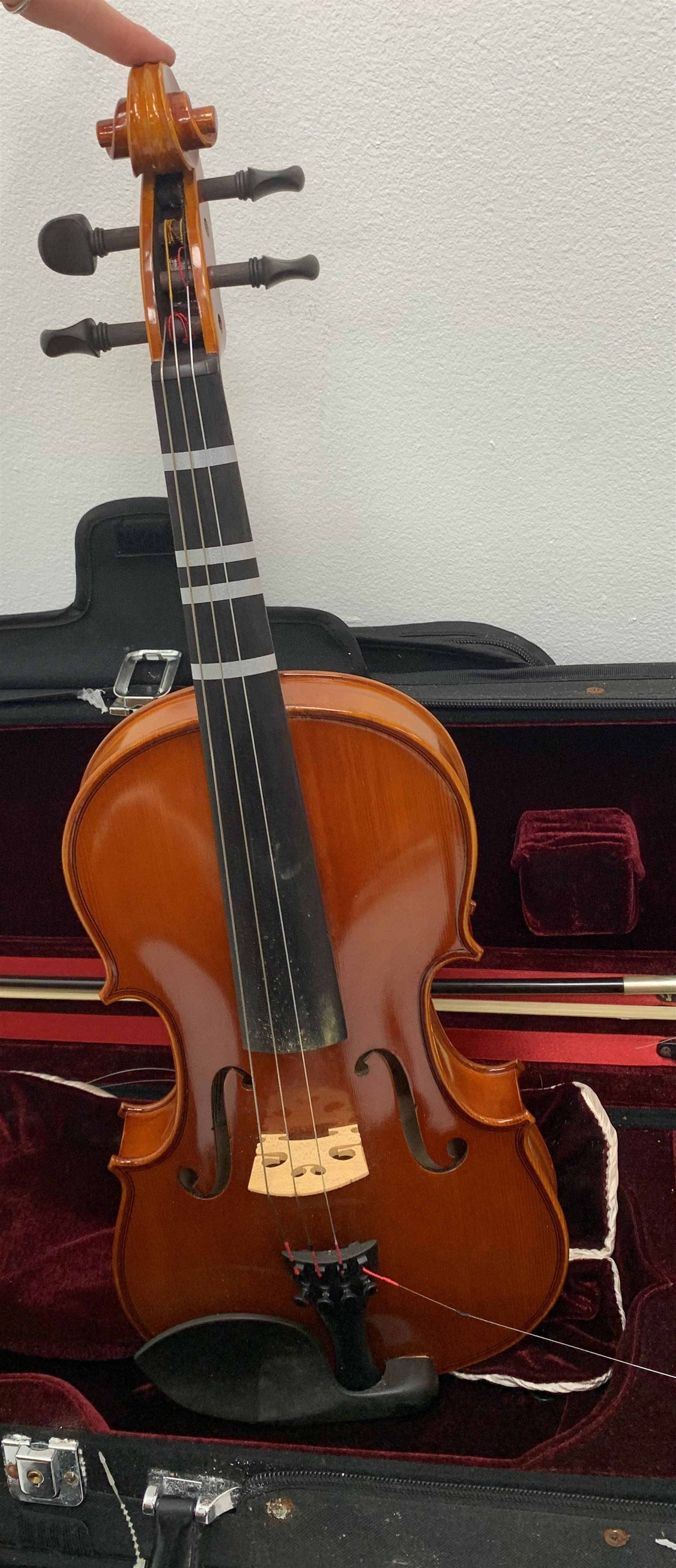 Three modern graduated violins - Suzuki 1/10 size child's violin with 23.5cm single piece back, bears label serial no.94282, 40cm overall; copy of Antonius Sradivarius of Cremona violin dated 1998 with 28cm two-piece back, 47cm overall; and Strobel violin with 35.5cm two-piece back, bears label dated 2006, serial no.512801325, 59cm overall. All cased with bows (3)
