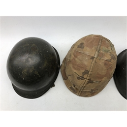  WW2 American M1 Steel helmet, with camouflauged cover, another with net, interior marked F.Ae/LM J.M.L '60, U.M.A.L, another  interior pencilled Weaver, all with liners and chinstraps (3)  