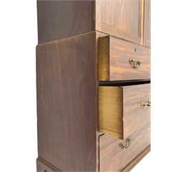 George III mahogany Gentleman's linen press, the projecting cornice over two panelled cupboard doors enclosing three sliding trays, the base fitted with two short over three long graduating cock-beaded drawers, lower moulded edge over bracket feet