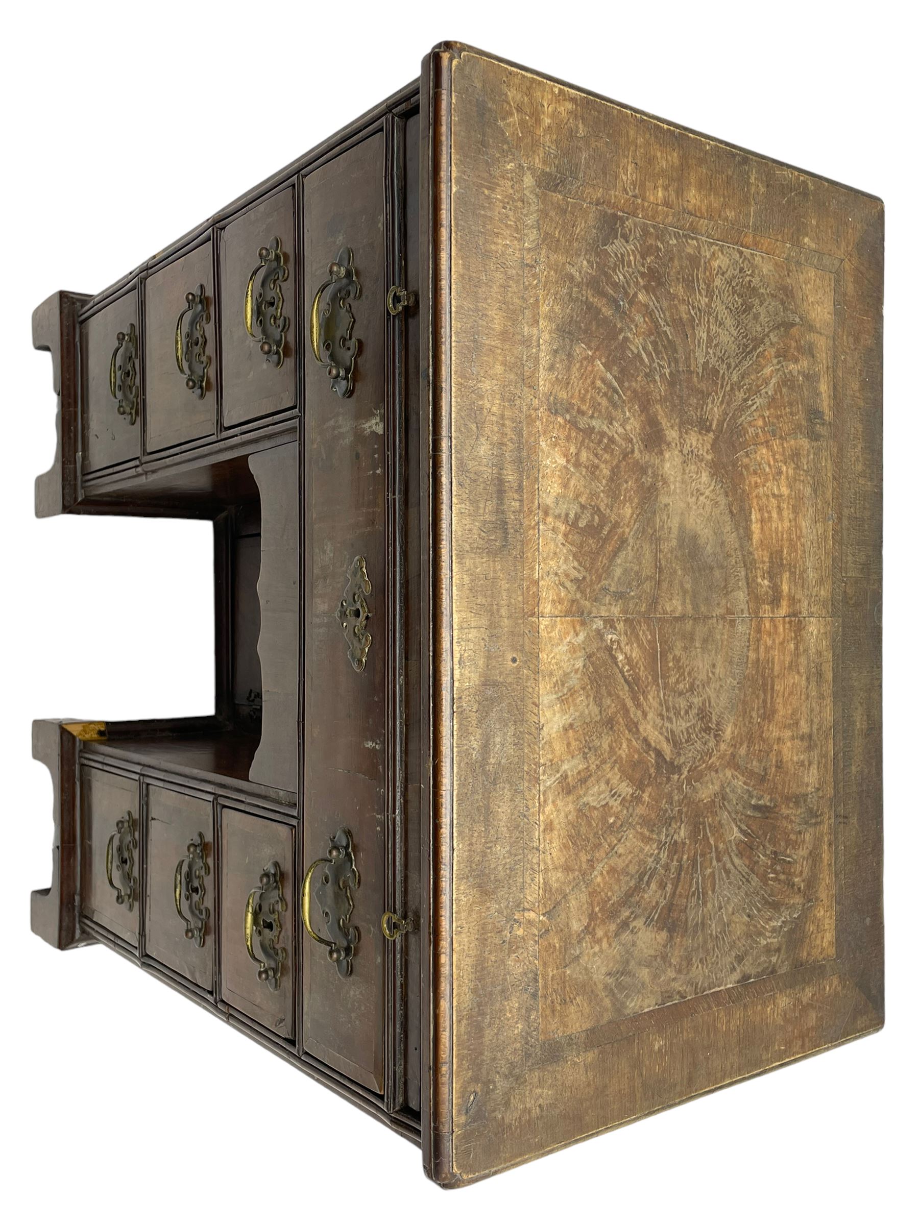 Georgian walnut kneehole desk, moulded rectangular top with book-matched veneers within crossbanding, fitted with slide over one long drawer, frieze drawer, six small drawers and recessed cupboard, raised on bracket feet
