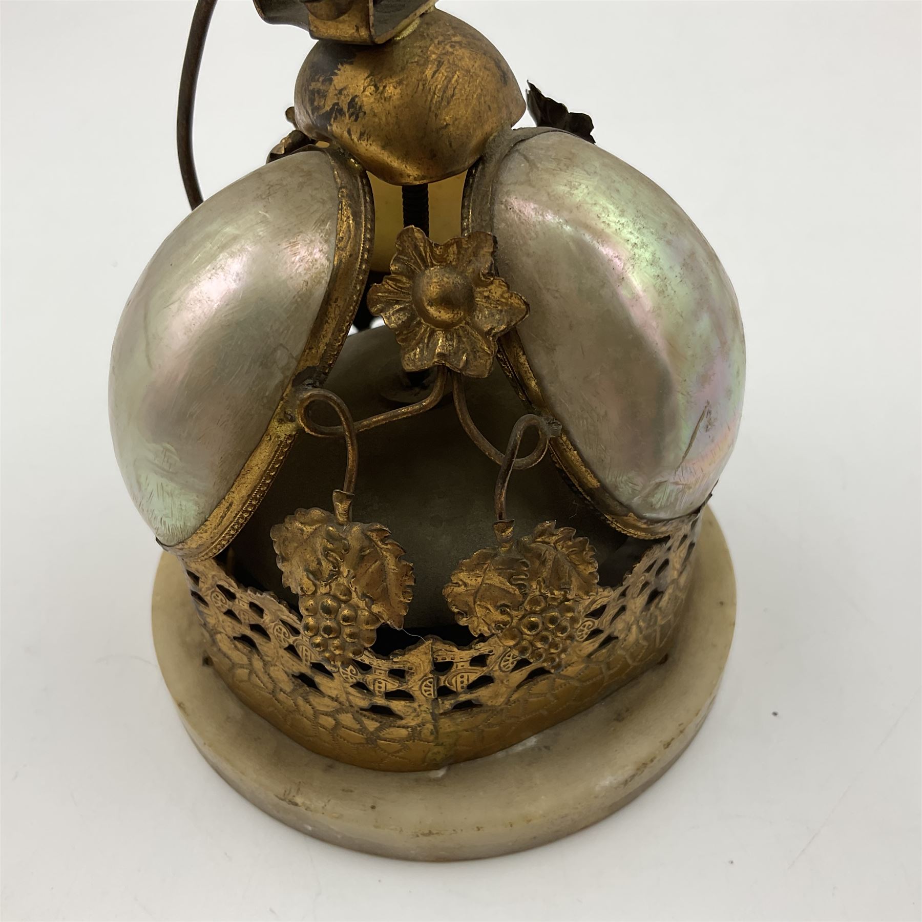 Victorian evening dinner bell, with three mother of pearl shells, floral and grape gilt decoration, and bird finial, raised upon a circular soapstone base with gilt pierced gallery, H14cm